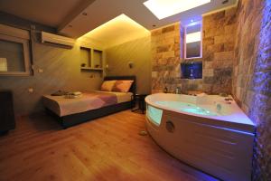 uma casa de banho com banheira e uma cama num quarto em Wonderland spa apartment em Niš