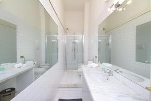 - Baño blanco con 2 lavabos y ducha en Da Sabrina Cavour 57 en Roma