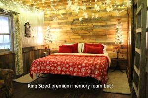 ein Schlafzimmer mit einem Bett und einer Holzwand in der Unterkunft The Christmas Cabin in Ozark