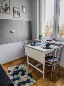une cuisine avec une table blanche et deux chaises dans l'établissement Apartament na Osiedlowej, Ciechocinek, à Ciechocinek