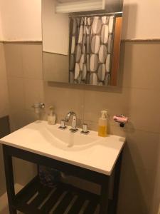 ein weißes Waschbecken in einem Badezimmer mit einem Spiegel in der Unterkunft La mansa in Puerto Madryn