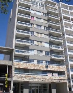 ein hohes Gebäude mit Balkonen an der Seite in der Unterkunft La mansa in Puerto Madryn