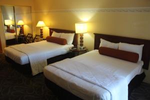 Habitación de hotel con 2 camas y espejo en Shalimar Hotel of Las Vegas en Las Vegas