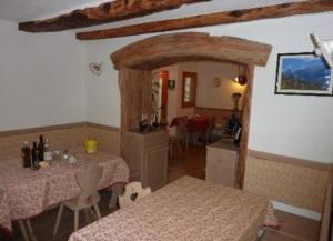 a living room with two tables and a room with at Agriturismo Plan Da Crosc in Prato Carnico