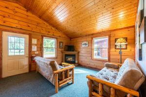 a living room with two chairs and a fireplace at Spur of the Moment Ranch in Mountain