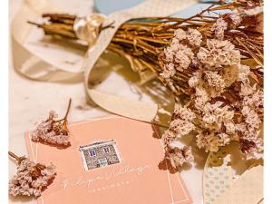 a bouquet of flowers on a table with a card at Filipe Village - Casa da Índia in Sesimbra