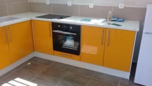 La caraïbe dans la station balnéaire في سانت فرانسوا: مطبخ مع دواليب برتقال وفرن اسود +12 صورة