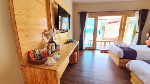 Una habitación de hotel con un dormitorio con una cama y un televisor. en Zodiac Seesun Resort, en Ko Lipe