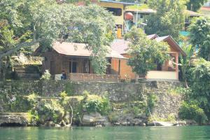 a house on the banks of a river at Reggae Guest House in Tuktuk Siadong