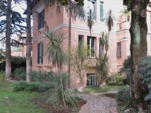 a pink building with palm trees in front of it at Villino Corbelli B&B in Rome
