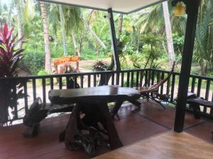 a hammock on a porch with a view of the jungle at Phumiphat resort Koh Mook in Trang