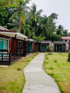 une passerelle en face d'un complexe avec des palmiers dans l'établissement Phumiphat resort Koh Mook, à Trang