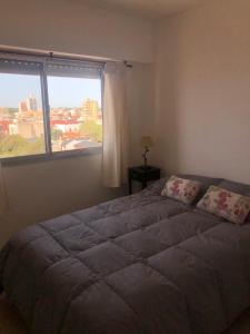 a bedroom with a large bed with a large window at Departamento frente al mar in Santa Teresita +26 photos