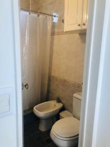 a small bathroom with a toilet and a sink at Departamento frente al mar in Santa Teresita