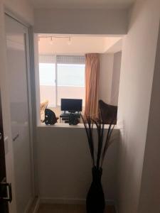 een kamer met een raam en een bureau met een laptop bij Departamento frente al mar in Santa Teresita