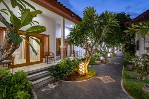 a walkway in front of a house with trees at Nusa Indah Bungalow in Nusa Lembongan