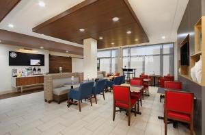 a restaurant with tables and chairs and a piano at Holiday Inn Express & Suites - Brookshire - Katy Freeway, an IHG Hotel in Brookshire