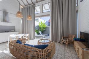a living room with a couch and a table and chairs at White Studio, villa with private pool Canggu in Canggu