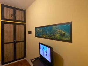 a room with a flat screen tv and an aquarium at Guarapari ES apartamento frente para o mar in Guarapari