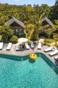 a pool with chairs and a frisbee in the water at Kashantee Village in Seminyak