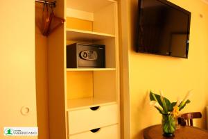 une étagère avec un four micro-ondes et une télévision dans l'établissement Hotel Americano, à Arica