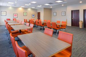 una sala de conferencias con mesas de madera y sillas naranjas en Holiday Inn Express Hotel & Suites Abilene Mall South, an IHG Hotel, en Abilene