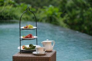 a plate of food on a stand with plates of food at Puri Sebali Resort in Ubud
