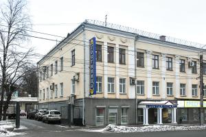 キーロフにあるHotel Preobrazhenskayaの青い看板が立つ白い大きな建物