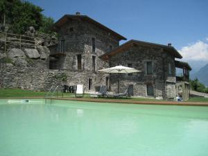 uma casa com piscina em frente a um edifício em Borgo Erbiola em Colico