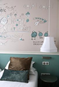 a bedroom with a bed with a happy lets party wall at Hôtel des 3 Poussins in Paris