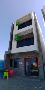 a building with colorful chairs in front of it at Oppa Homestay in Magong