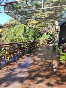 un patio con pérgola, mesa y bancos en Shan Ju Lake Villa en Renai