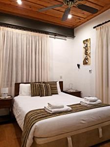 a bedroom with a large bed with towels on it at Archontiko I Misirlou in Kalopanayiotis