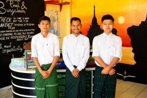 een groep van drie mannen die voor een toonbank staan bij Lover View Pool Bar & Bungalows in Ngwesaung