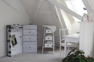 a room with a desk and a refrigerator and a table at Bed and Breakfast Gantrisch Cottage Ferienzimmer in Rüeggisberg