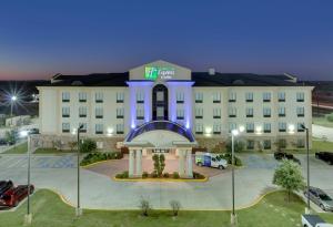 Holiday Inn Express Denton UNT TWU, an IHG Hotel في دينتون: مبنى ابيض كبير عليه ساعه