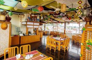 a dining room with tables and chairs in a restaurant at Shwe Kyun Hotel in Taunggyi