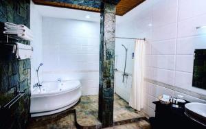 a bathroom with a tub and a shower and a sink at Shwe Kyun Hotel in Taunggyi +19 photos
