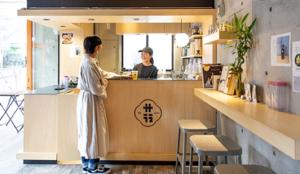 une femme debout au comptoir d'un restaurant dans l'établissement treeside, à Yugawara