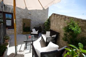 un patio al aire libre con sillas y sombrilla en Residence Erice Pietre Antiche en Erice