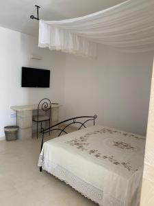 a bedroom with a bed and a desk and a television at Agriturismo Messer Gesualdo in Nociglia