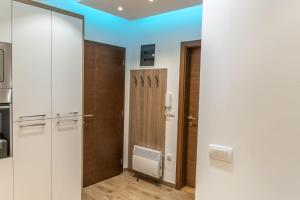 um corredor com armários brancos e uma porta de madeira em Apartments Mikic Zlatibor em Zlatibor