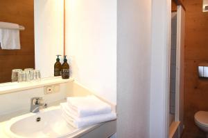 a bathroom with a sink and a mirror and towels at Alps Hostel in Pfronten