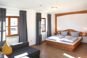 1 dormitorio con 1 cama y 1 sofá en Alps Hostel en Pfronten