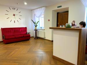 a room with a red couch and a clock on the wall at RioRo in Myrhorod