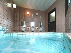 a bathroom with a large pool of blue water at Nanakuraso in Omachi