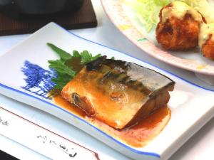 un plato de comida con un pedazo de pescado y una ensalada en Nanakuraso en Omachi