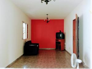 sala de estar con pared roja y TV en casa de temporada, en São Lourenço