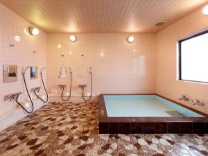 a large bathroom with a tub and two sinks at Hotel Mimatsu in Nara