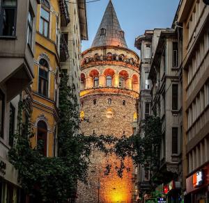 ein hohes Gebäude mit einem Turm auf einer Straße in der Unterkunft Grand Kavi Hotel in Istanbul